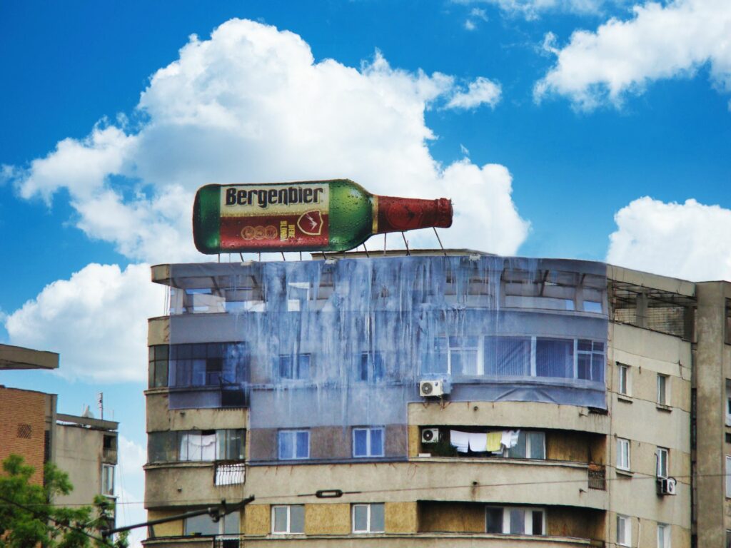 La marque de bière roumaine fait appel à un trompe l'oeil lumineux géant ainsi qu'une toile en trompe l'œil pour faire sa communication.